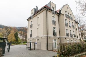 a large building with a fence in front of it at VacationClub – Zdrojowa 7 Apartament 6 in Duszniki Zdrój
