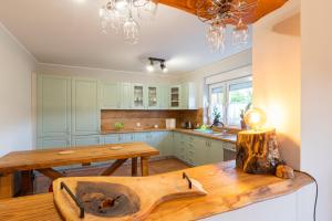 a kitchen with green cabinets and a wooden table at Odpoczywajka in Borucino
