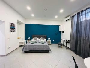 a bedroom with a blue wall and a bed at La Casa di NAra in Naples