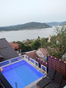 a swimming pool on a roof with a view of a lake at Casa Clau Cazare Orșova in Orşova