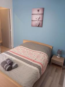 een slaapkamer met een bed met een paar slippers erop bij Résidence de l'évèché 7 in Limoges