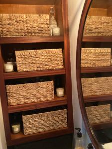 a bathroom shelf with baskets and a mirror at Ahoy London in London