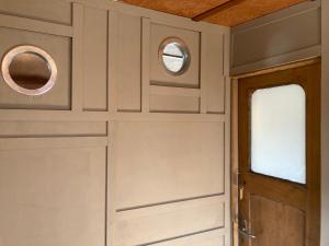 a kitchen with white cabinets and a door with two windows at Ahoy London in London