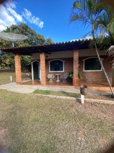 a brick house with a palm tree in front of it at Chalés Holiday House in Rio Quente