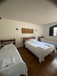 a bedroom with two beds and a flat screen tv at Chalés Holiday House in Rio Quente