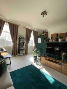 a living room with a flat screen tv and a couch at One Bedroom Flat in the heart of Islington in London