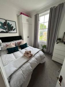 a bedroom with a large bed with a teddy bear on it at One Bedroom Flat in the heart of Islington in London