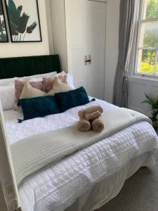 a teddy bear sitting on top of a bed at One Bedroom Flat in the heart of Islington in London