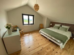 a bedroom with a bed and a wooden floor at Gîte au cœur des Gorges de la Loire in Aurec-sur-Loire