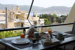 un tavolo con piatti di cibo su un balcone di Blue Side Apartment in Porto Rafti a Porto Rafti