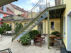 eine Terrasse mit einer Treppe, einem Tisch und Stühlen in der Unterkunft Goldener Anker, verschiedene gemütliche Ferienwohnungen in Rheinsberg