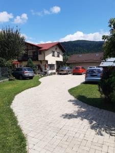 a driveway with cars parked in front of a house at Casa cu Flori in Buşteni