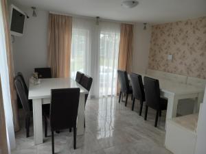 a dining room with a white table and black chairs at CASA LENA -VATRA DORNEI in Vatra Dornei
