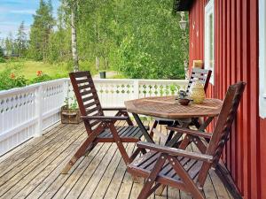 une table en bois et deux chaises sur une terrasse dans l'établissement Holiday home Gnesta II, à Gnesta