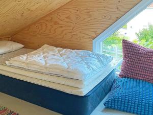 uma cama sentada num quarto ao lado de uma janela em Holiday home HUNNEBOSTRAND XI em Hunnebostrand