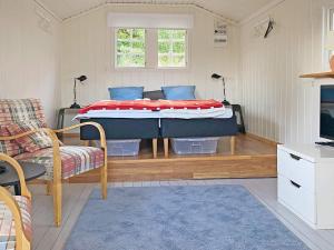 um quarto com uma cama, um sofá e uma televisão em Holiday home HUNNEBOSTRAND XI em Hunnebostrand