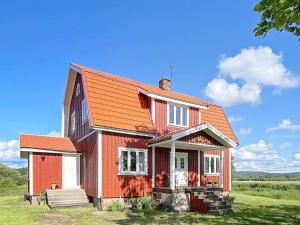 uma casa vermelha com um telhado laranja em Holiday home VÄSTRA ÄMTERVIK em Östra Ämtervik