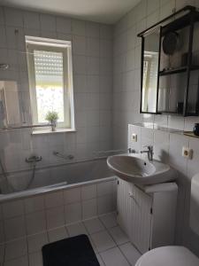 y baño con bañera, lavamanos y bañera. en A9 Apartment, en Ingolstadt