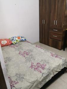 1 dormitorio con 1 cama con edredón de flores en Apartamento Jonas, en Ibagué