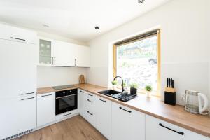 a kitchen with white cabinets and a window at Domek pod Magurką in Międzybrodzie Bialskie