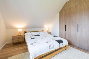 1 dormitorio con 1 cama y armario de madera en Domek pod Magurką en Międzybrodzie Bialskie