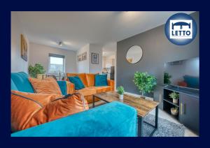a living room with orange and blue couches and a table at Letto Serviced Accommodation Peterborough - Oakcroft House - PE7 FREE Parking in Peterborough