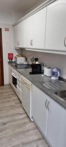 a kitchen with white cabinets and a counter top at Marear in Porto Santo