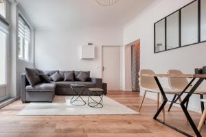 a living room with a couch and a table at Superbe 2 pièces avec Jacuzzi privatif face Gare Proche Cathédrale in Chartres