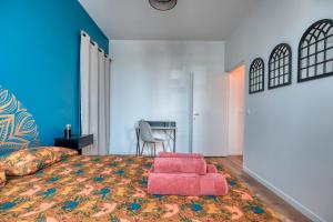 a bedroom with a bed with a pink foot stool at Superbe 2 pièces avec Jacuzzi privatif face Gare Proche Cathédrale in Chartres