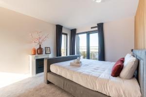 a bedroom with a bed and a large window at Beach Villa & Studio in Zandvoort
