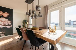 a dining room with a wooden table and chairs at Beach Villa & Studio in Zandvoort