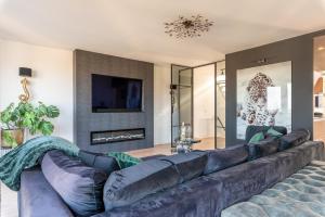 a living room with a large leather couch at Beach Villa & Studio in Zandvoort