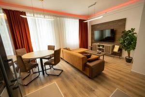 ein Wohnzimmer mit einem Tisch und einem Esszimmer in der Unterkunft 19th Floor Sunset Secure Condo with Pool & Fitness & Parking included in price in Skopje