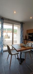 a table and a chair in a kitchen with a window at L'Escapade Cévenole in Le Collet-de-Dèze