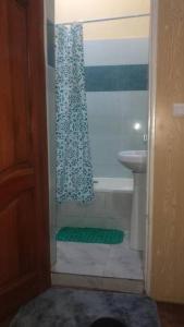 a bathroom with a shower curtain and a sink at Kajaga Tanganyika in Bujumbura