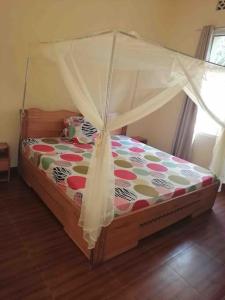 a bed with a canopy in a room at Kajaga Tanganyika in Bujumbura