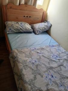 a bed with a wooden headboard and two pillows on it at Kajaga Tanganyika in Bujumbura
