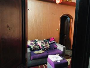 a living room with a purple couch with a box at شقة مفروشة in Mansoura