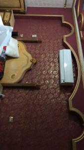 drewniana gitara leżąca na podłodze obok laptopa w obiekcie شقة مفروشة w mieście Al-Mansura