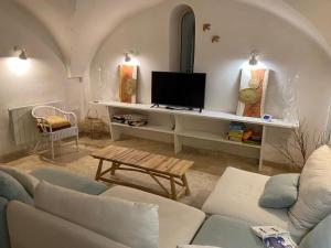 uma sala de estar com um sofá e uma televisão em La Gardette, Gordes, vue panoramique Ventoux em Gordes