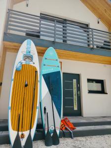 two surfboards are parked outside of a building at Dom nad jeziorem WIDOKówka in Żywiec