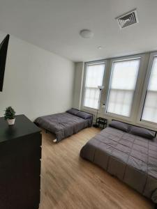 two beds in a room with windows at Close to NYC, 10 Guest, Luxurious 3Bedroom Apartment in Union City