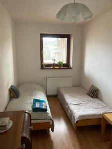 Duas camas num pequeno quarto com uma janela em U starkych em Poprad