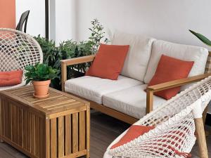 sala de estar con sofá y sillas de mimbre en Madeira Breeze, en Funchal