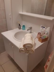 y baño con lavabo y toallas. en Residentie Lumina en Middelkerke
