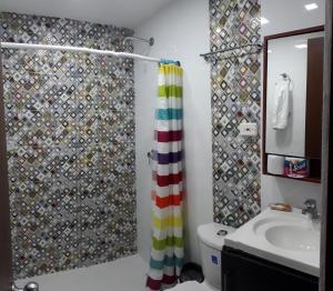 a bathroom with a shower curtain and a sink at Apartamentos sophia in San Andrés