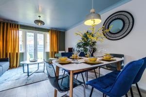 a dining room with a table and blue chairs at Newly Refurbished 3 Double Bedroom Knowsley Liverpool Townhouse in Knowsley