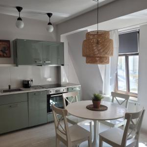 a kitchen with a table and a table and chairs at Apartamenty Batorego 4 in Bydgoszcz