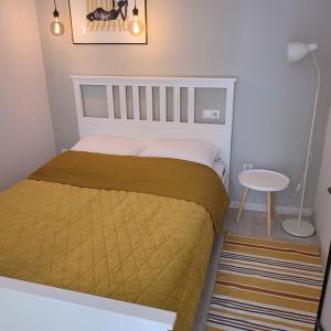 a small bedroom with a bed and a table at Apartamenty Batorego 4 in Bydgoszcz