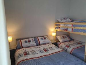two beds in a small room with two lamps at Immaculate 2-Bed Cottage - Free WiFi in Bridlington